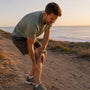 Runner pausing with calf muscle cramp outdoors