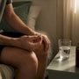 Runner hand holding magnesium capsule with water glass