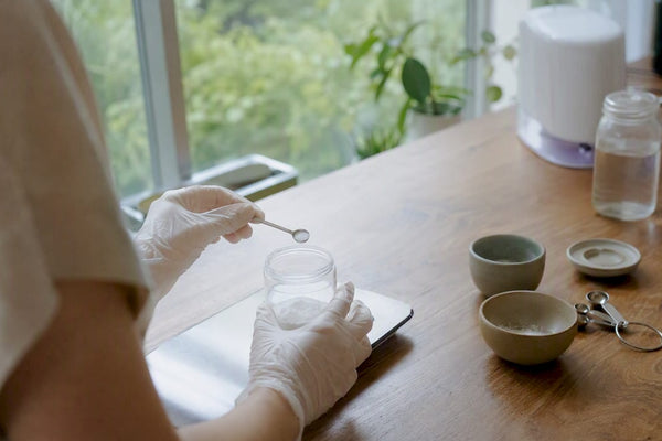 Gloved hand measuring powder sample in lab