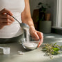 Hands scooping magnesium lactate powder with capsules