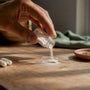 Hand pouring magnesium stearate powder into capsule