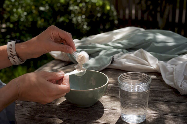 Hands scooping magnesium powder into a spoon