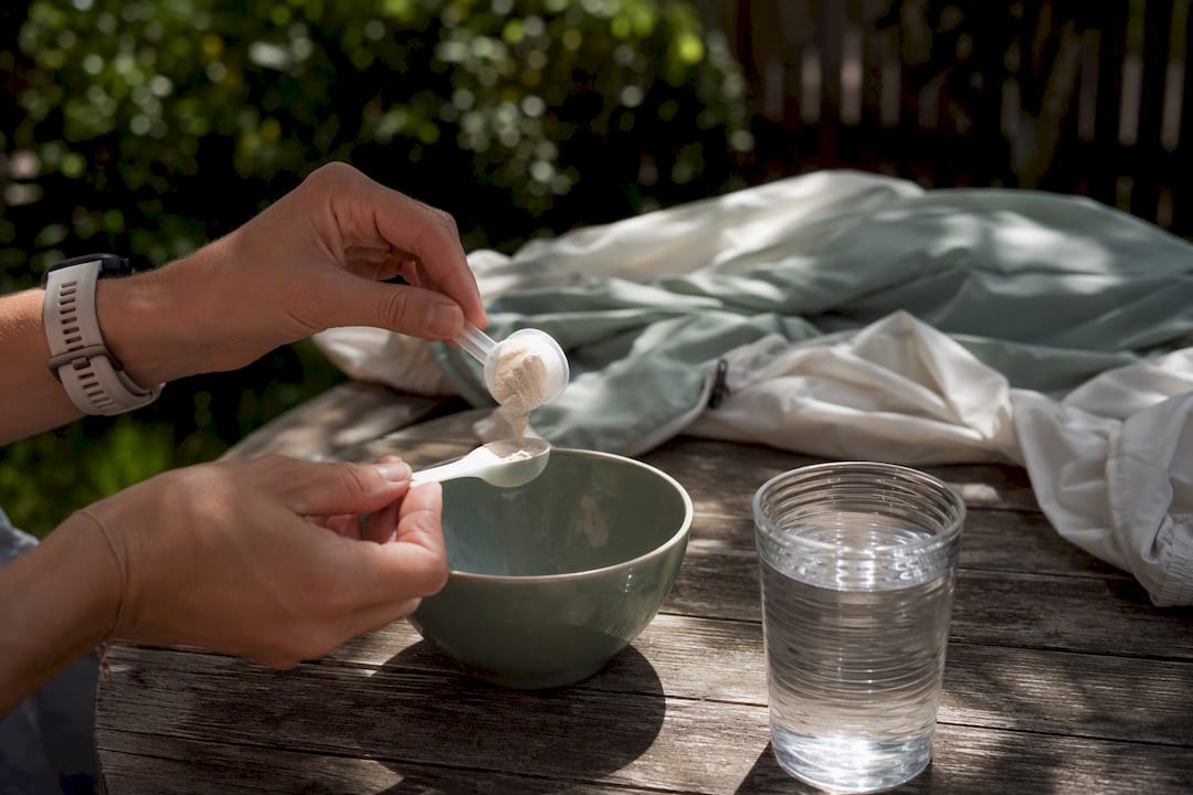 Hands scooping magnesium powder into a spoon