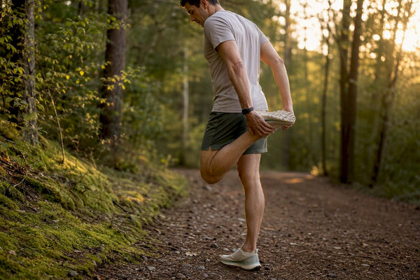 Runner stretching calves outdoors in morning light