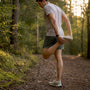 Runner stretching calves outdoors in morning light