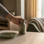 Hand placing supplement bottle on kitchen counter