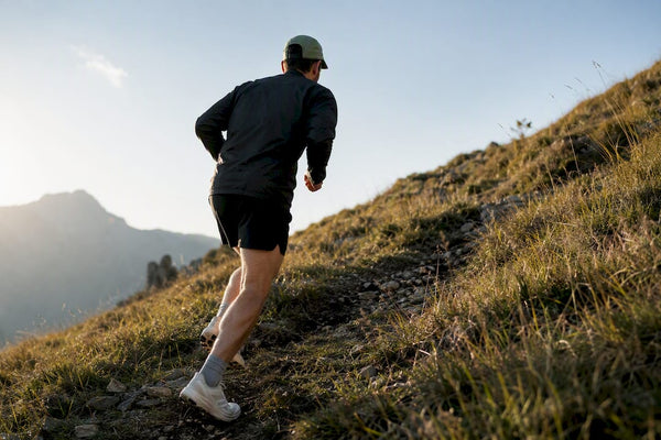 Runner powering uphill on a grassy trail