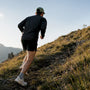Runner powering uphill on a grassy trail