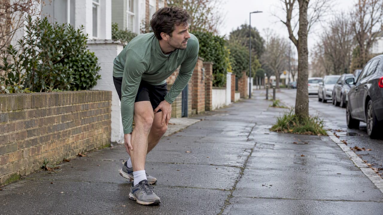 Runner pausing with a painful calf cramp
